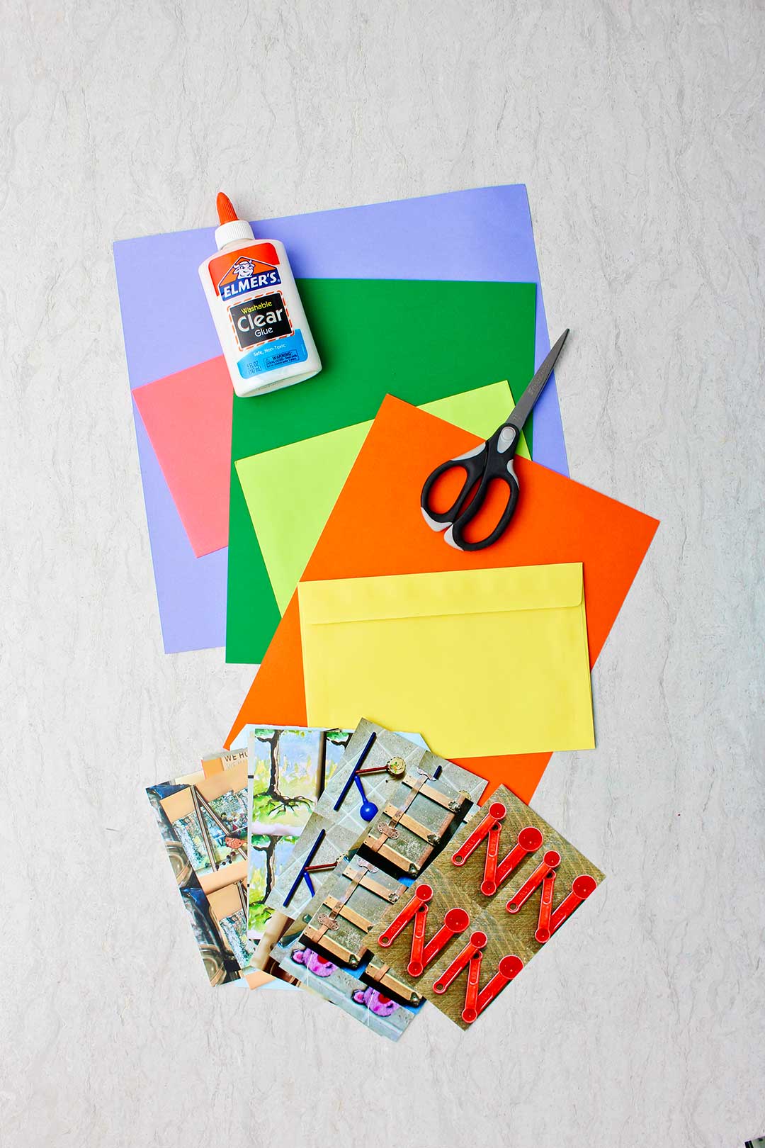 Colorful pieces of paper, white glue, scissors and printed photo letters.