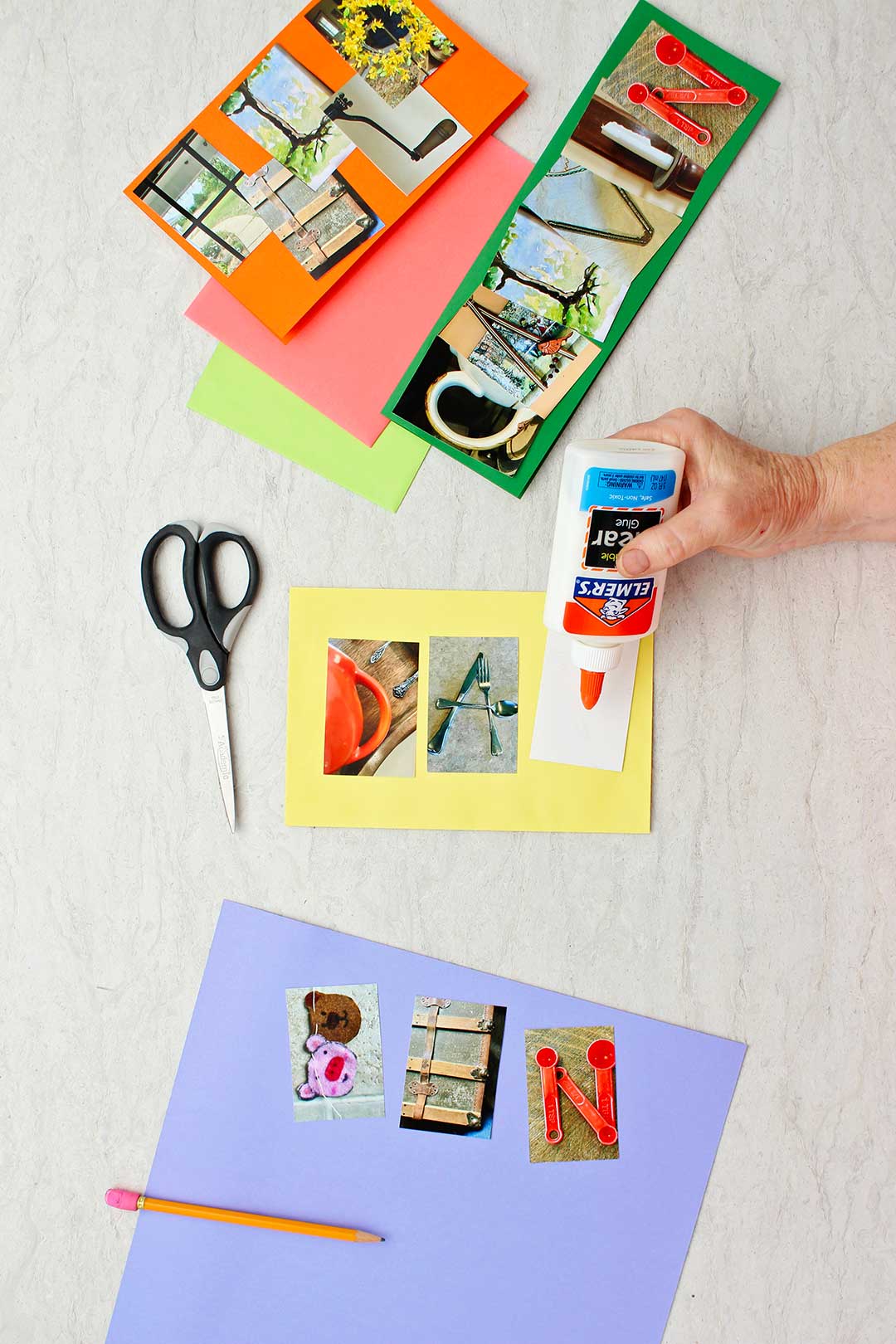 Hand holding white glue gluing a letter to a photo card on yellow paper.