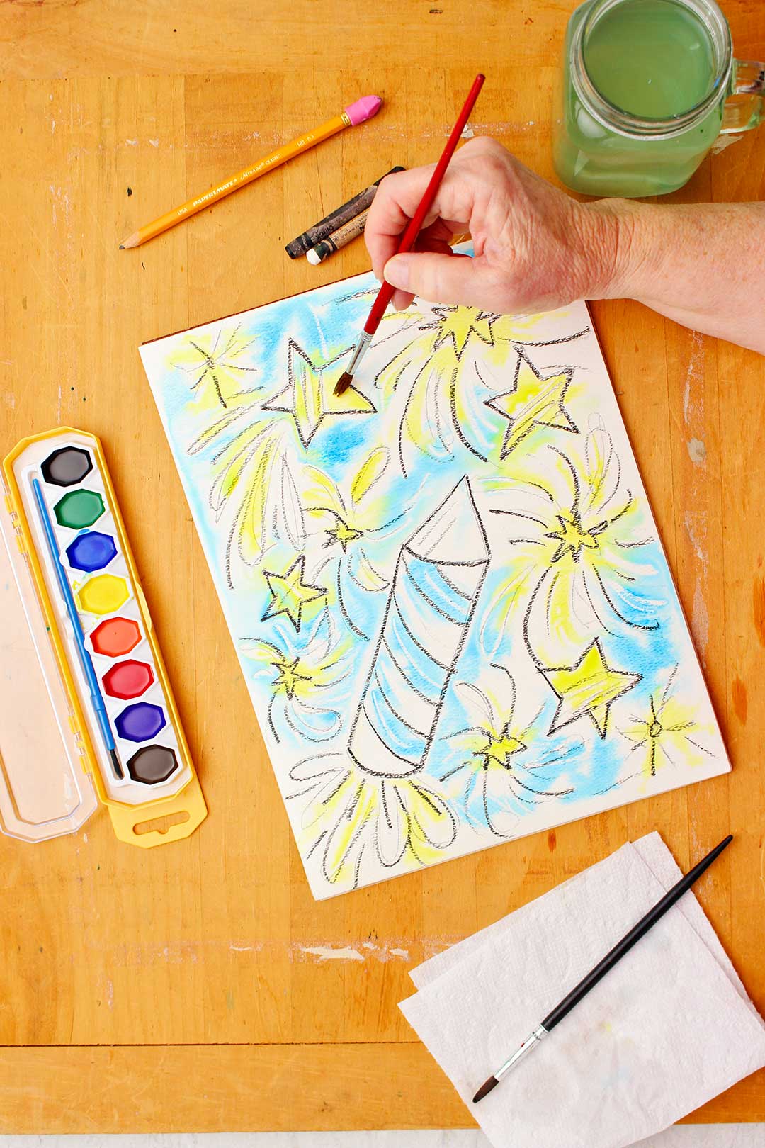 Hand painting stars yellow on the watercolor resist.