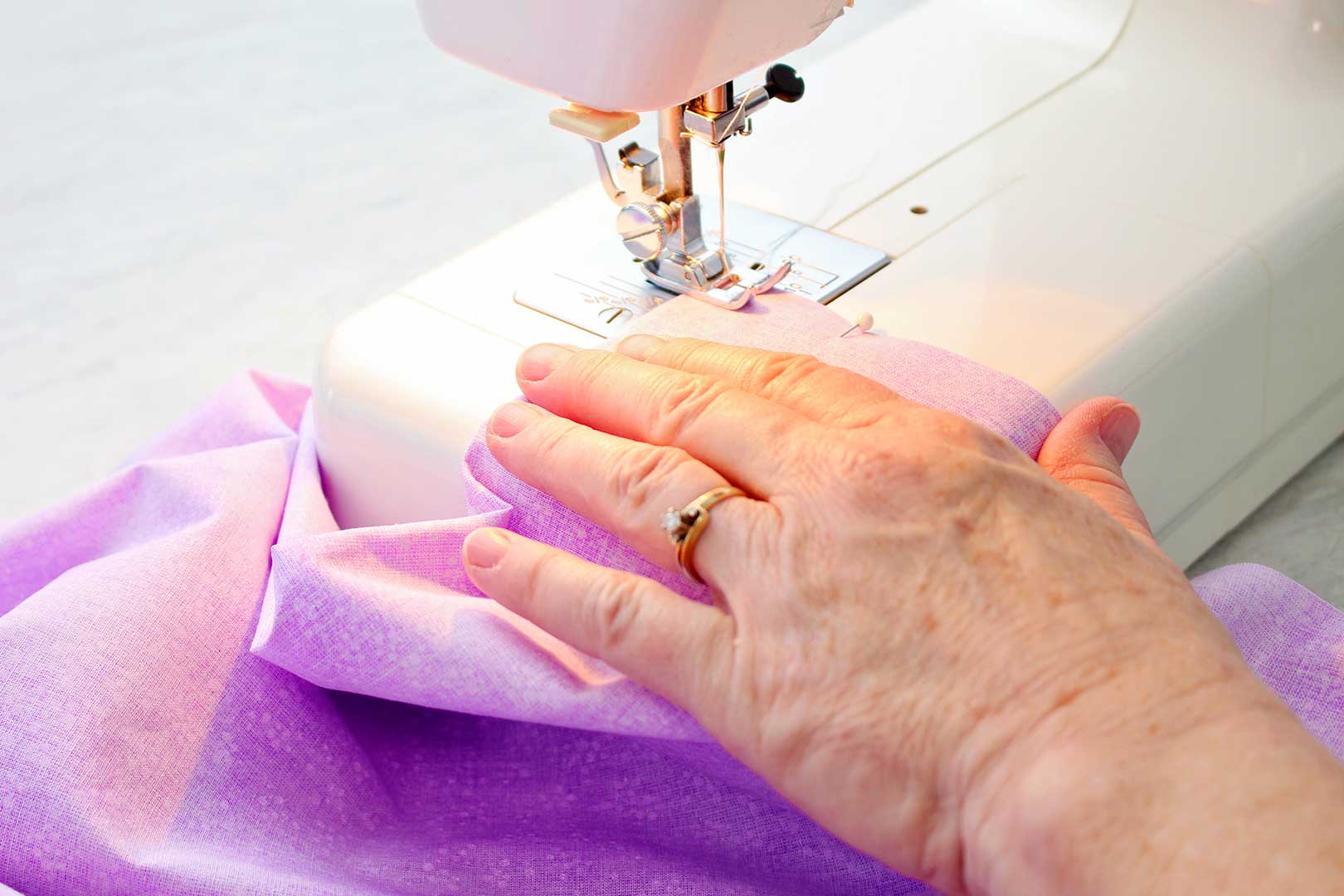 Hand sewing purple fabric for the pillowcase on a sewing machine.