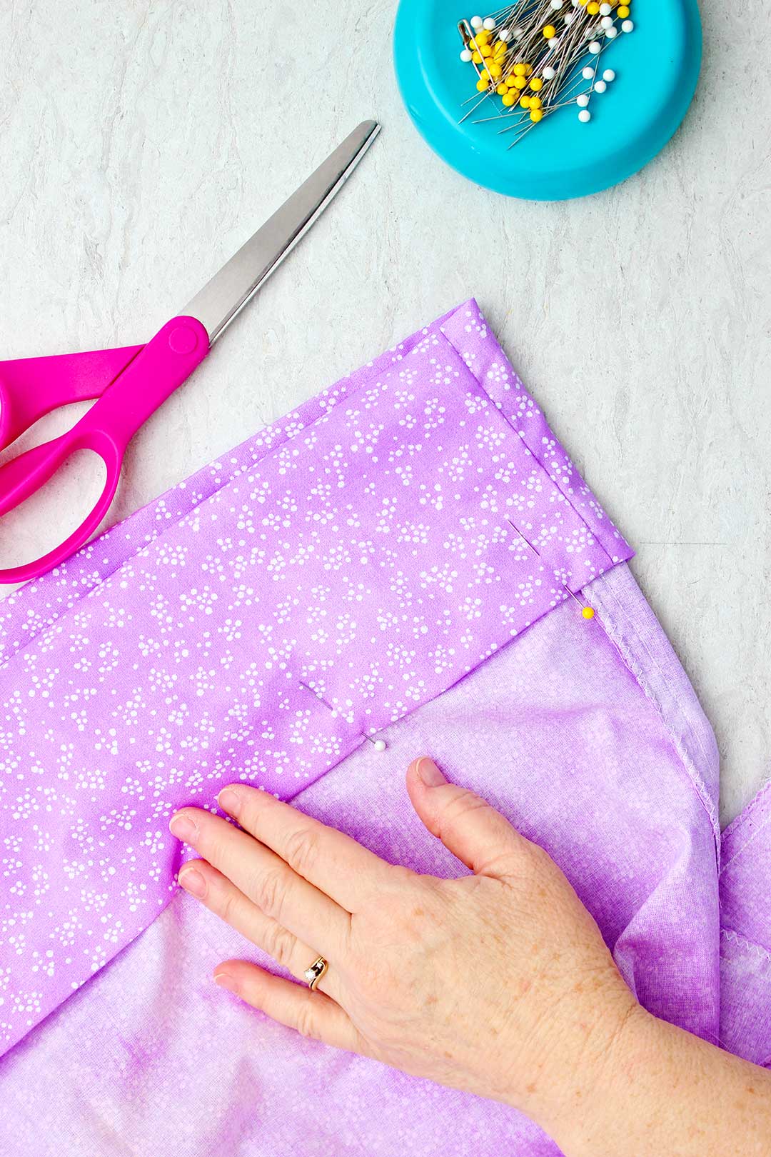 Hand pinning down the opening of an inside out pillowcase.