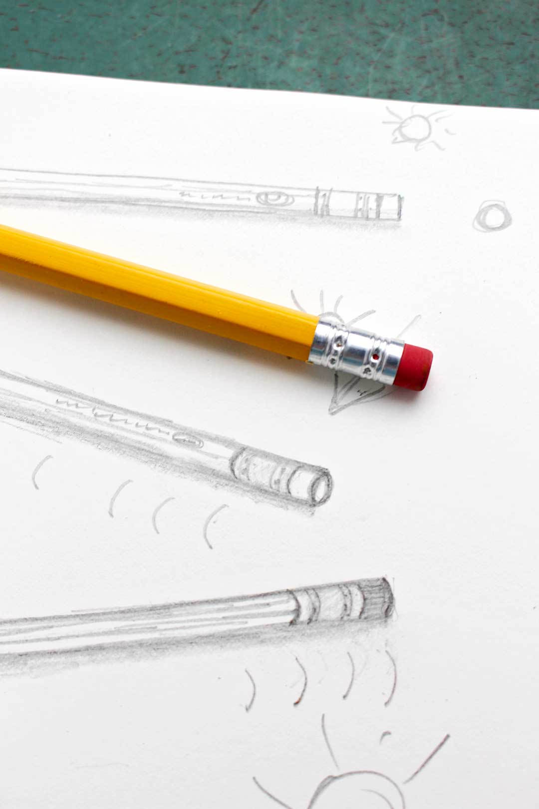 Close up view of the metal and eraser part of the pencil resting on sketch pad.