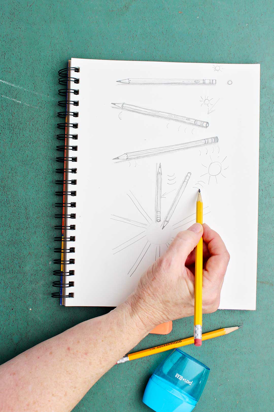 Hand showing direction of lines for pencils drawn in different directions.