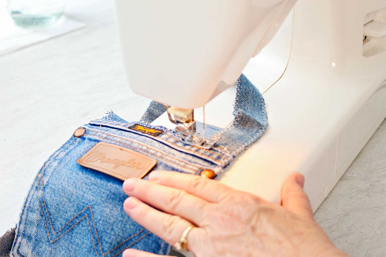 Hand sewing straps on pocket purse using a sewing machine.