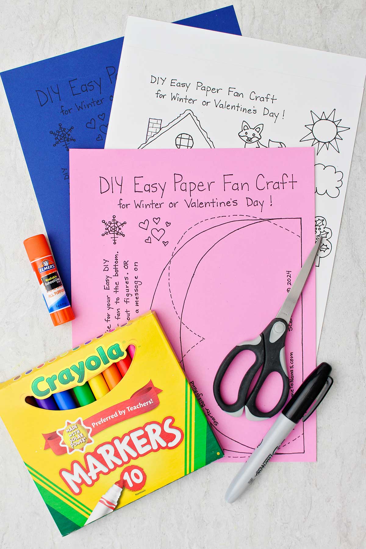 Printouts for winter and Valentine's Day Easy Paper Fan Crafts, a box of markers, glue stick, scissors and Sharpie.