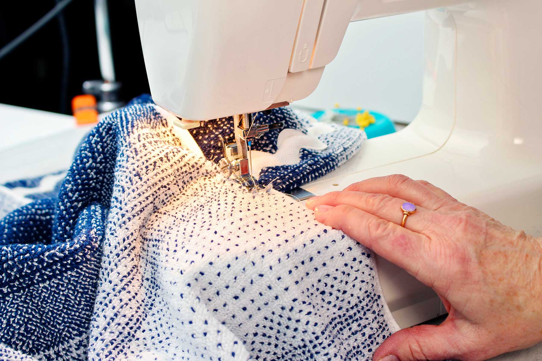 Hand sewing hood to towel with sewing machine.