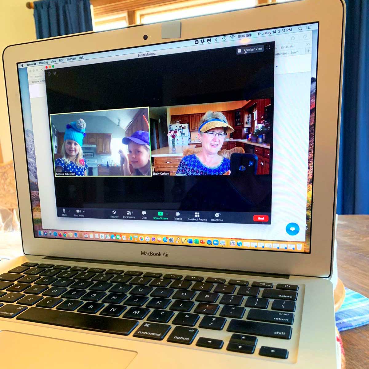 A computer with a video chat open, with a grandma and her grandchildren smiling on the screen