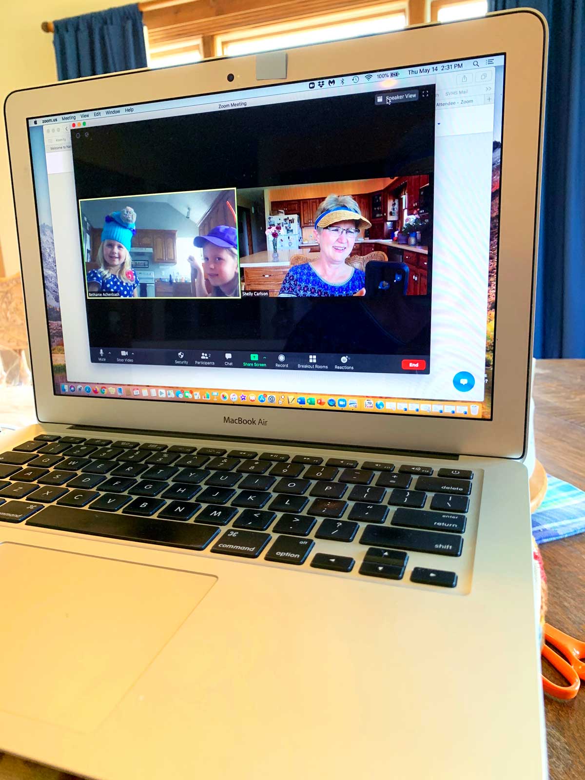 A computer with a video chat open, with a grandma and her grandchildren smiling on the screen