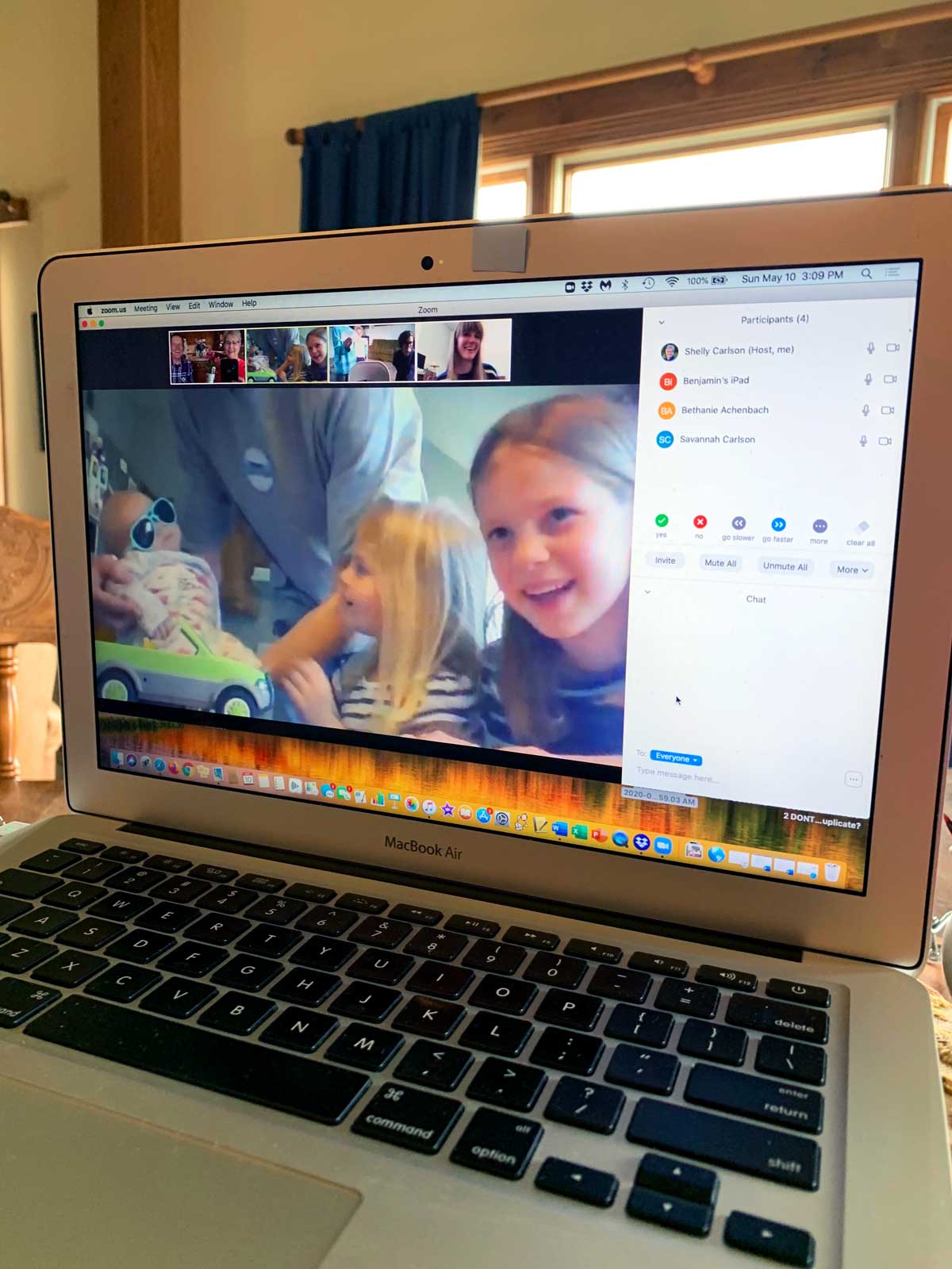 A computer with a video chat open, with children laughing on the screen