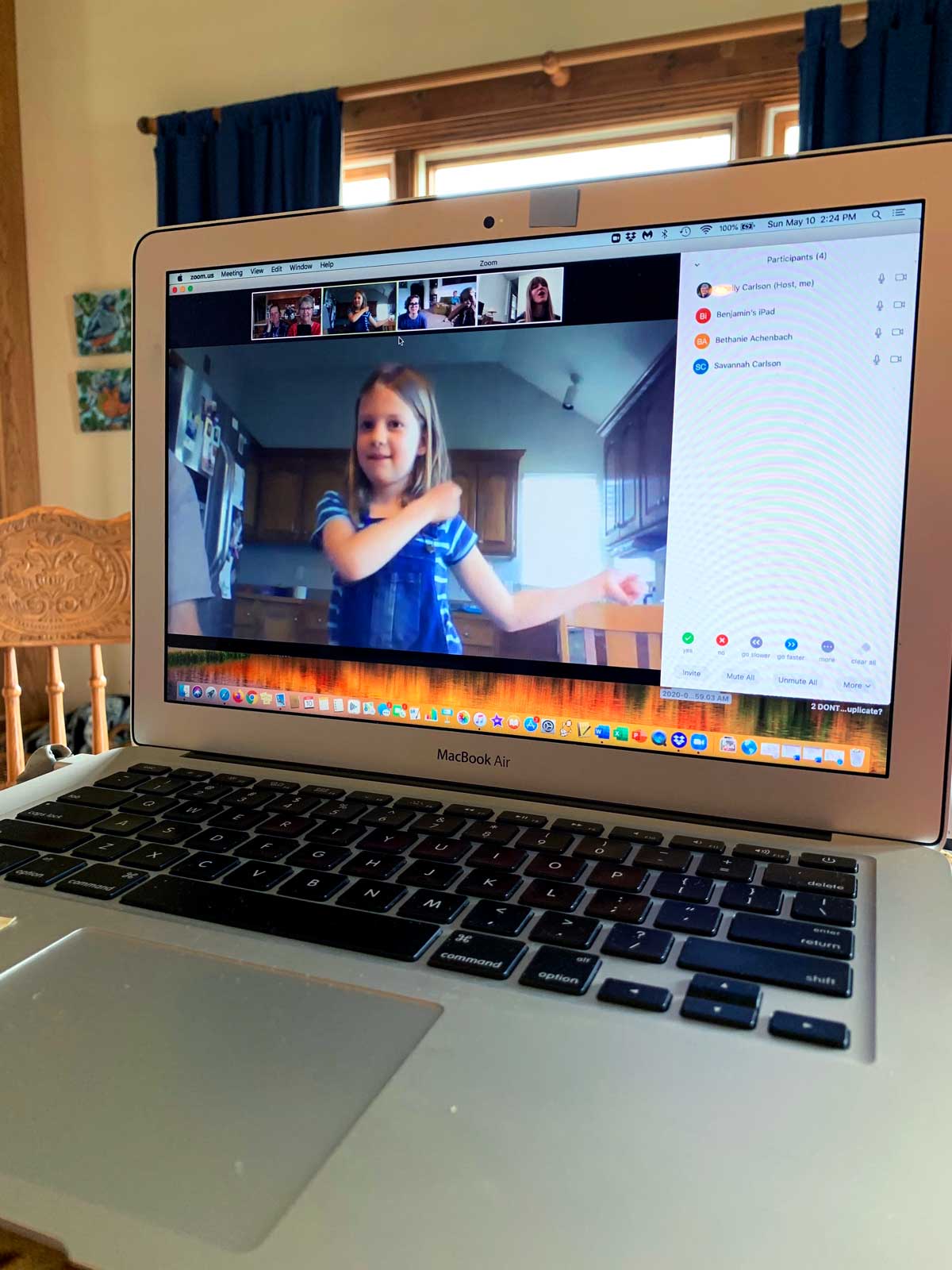 A computer with a video chat open, with a child acting out charades virtually
