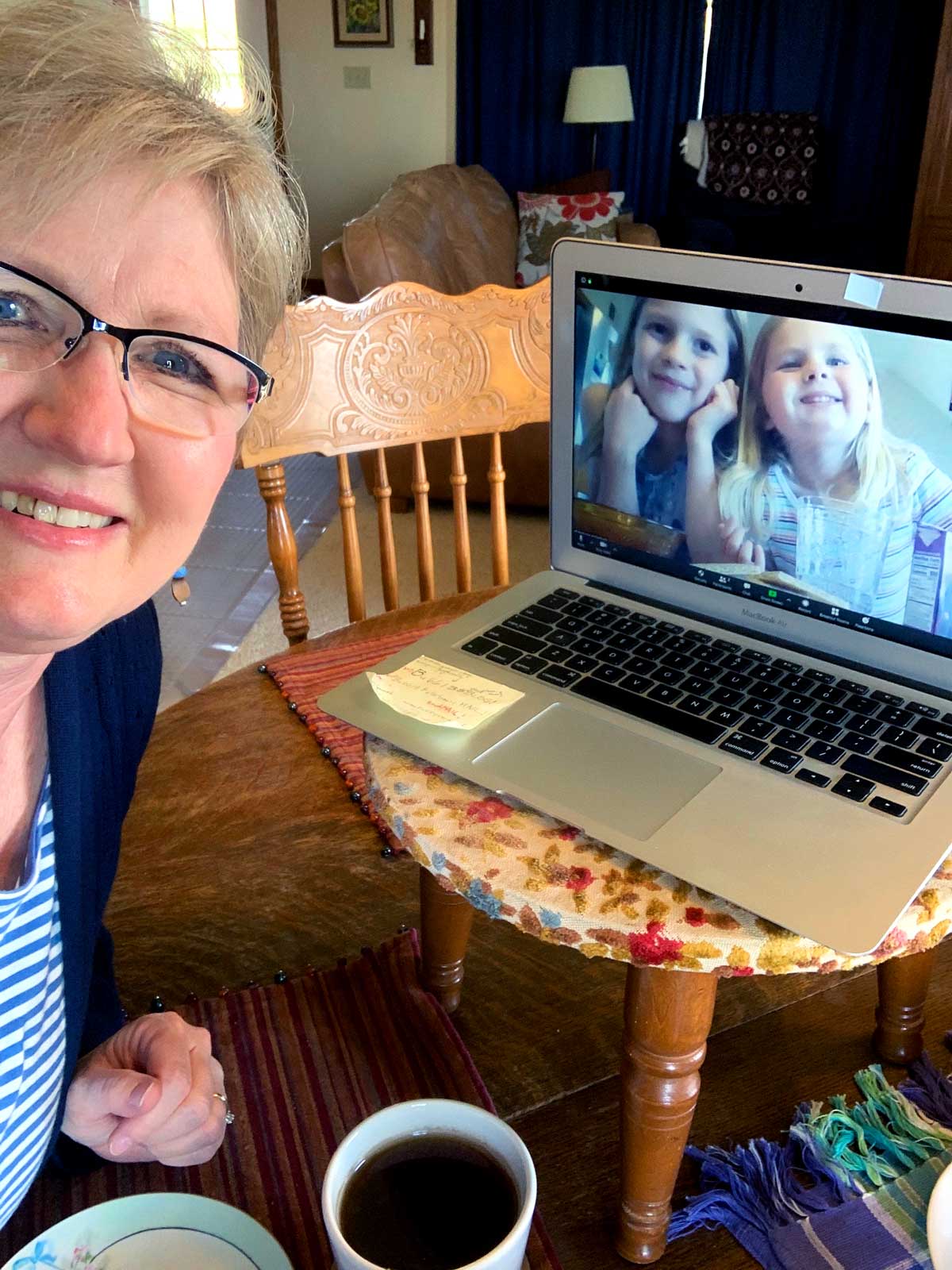 A grandma sitting near a computer, chatting virtually with her grandchildren