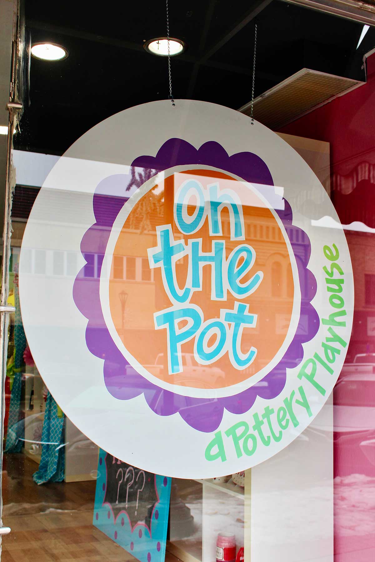 Window sign that says "On the Pot a Pottery Playhouse"