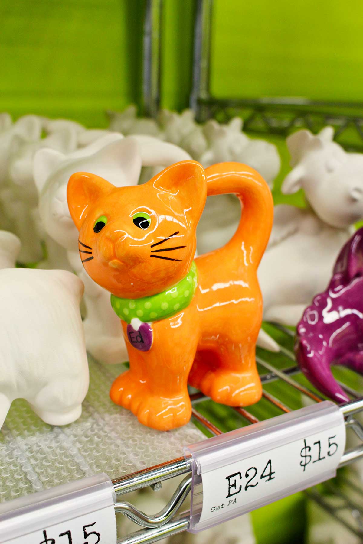 A small orange cat with green collar sample at ceramic painting studio.