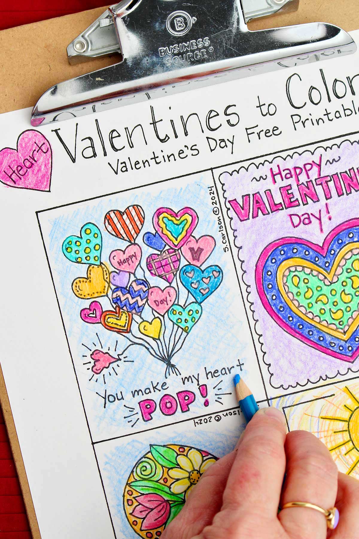 Hand using blue colored pencil to shade in background of Valentine saying "You make my heart POP!"