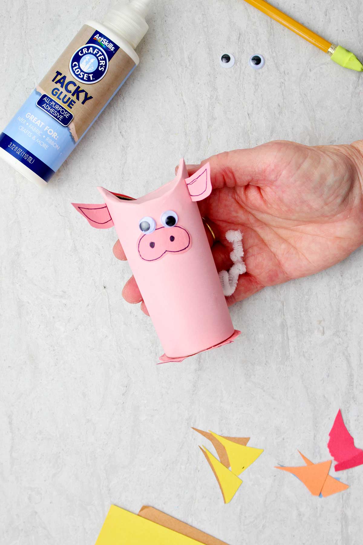 Hand holding pig toilet paper roll animal.