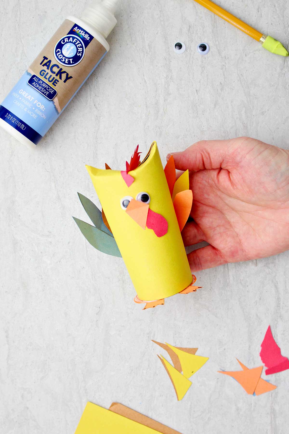 Hand holding chicken toilet paper roll animal.
