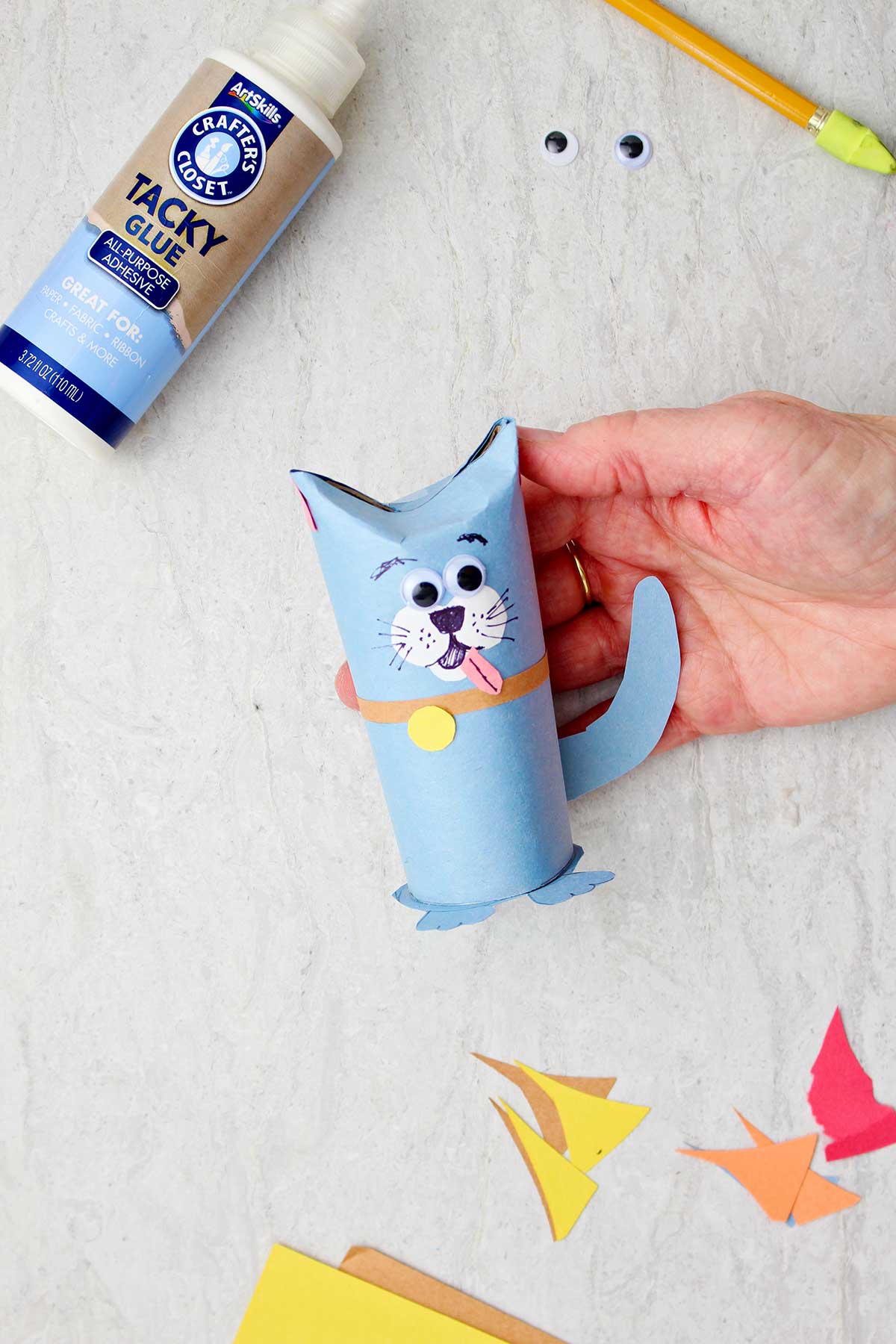 Hand holding dog toilet paper roll animal.