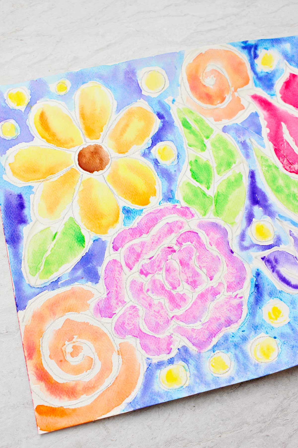 Close up view of a couple of flowers on the left side of the glue line painting.