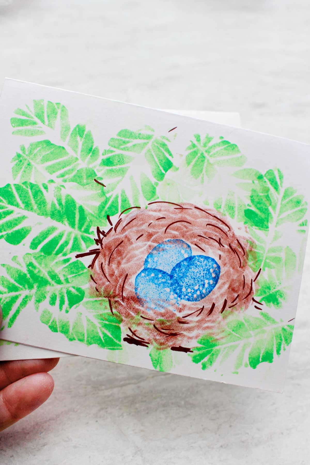 Print of leaves, a nest and eggs.