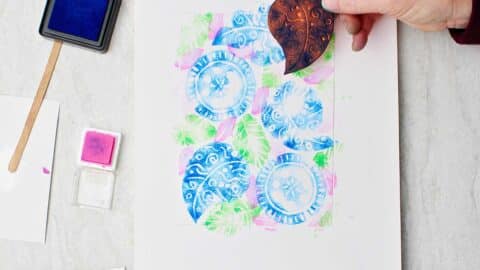 Hand holding craft foam stamp and showing the camera the underside with ink on it.