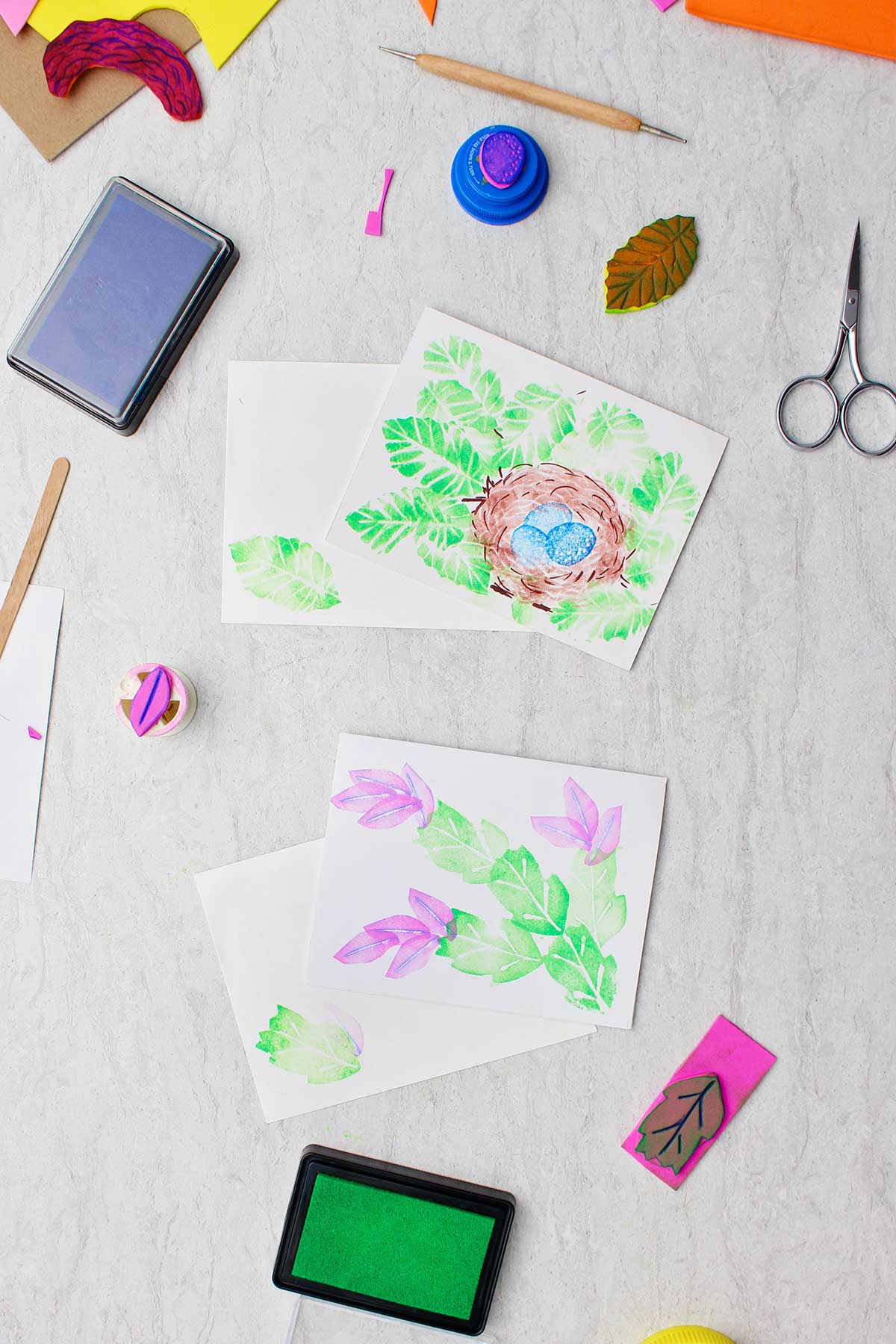 Completed botanical prints made with craft foam stamps with supplies near by.