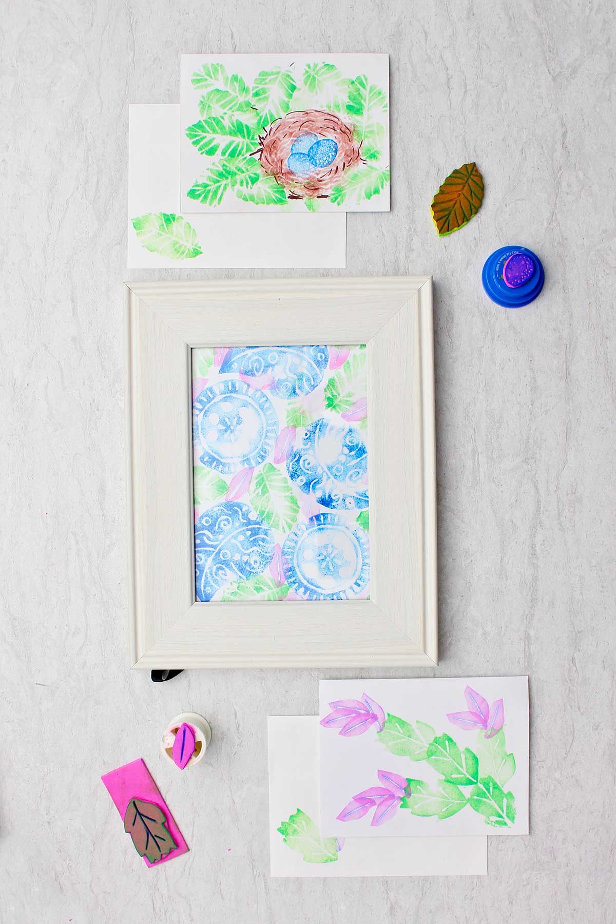 Finished prints made with craft foam stamps, center print is in white frame.