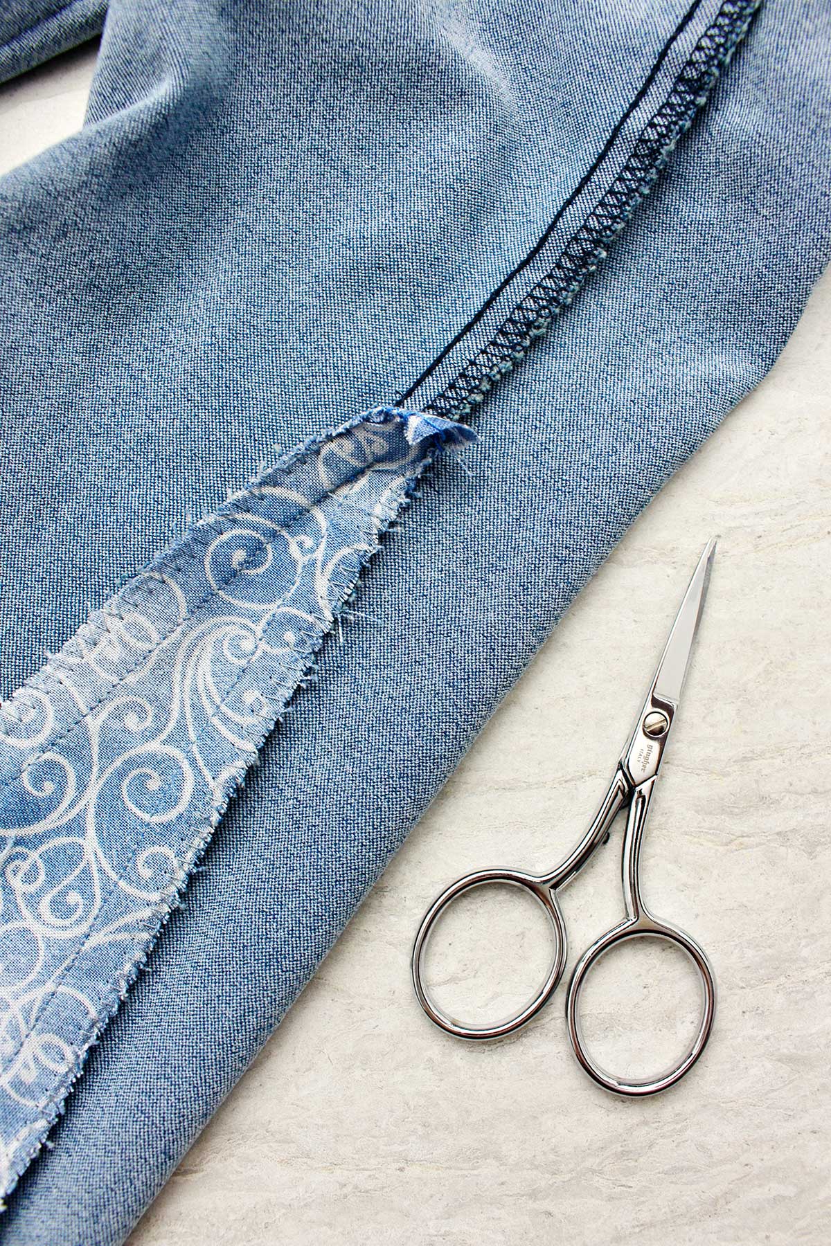 Close up view of inside out jeans with piece of fabric sewn in.