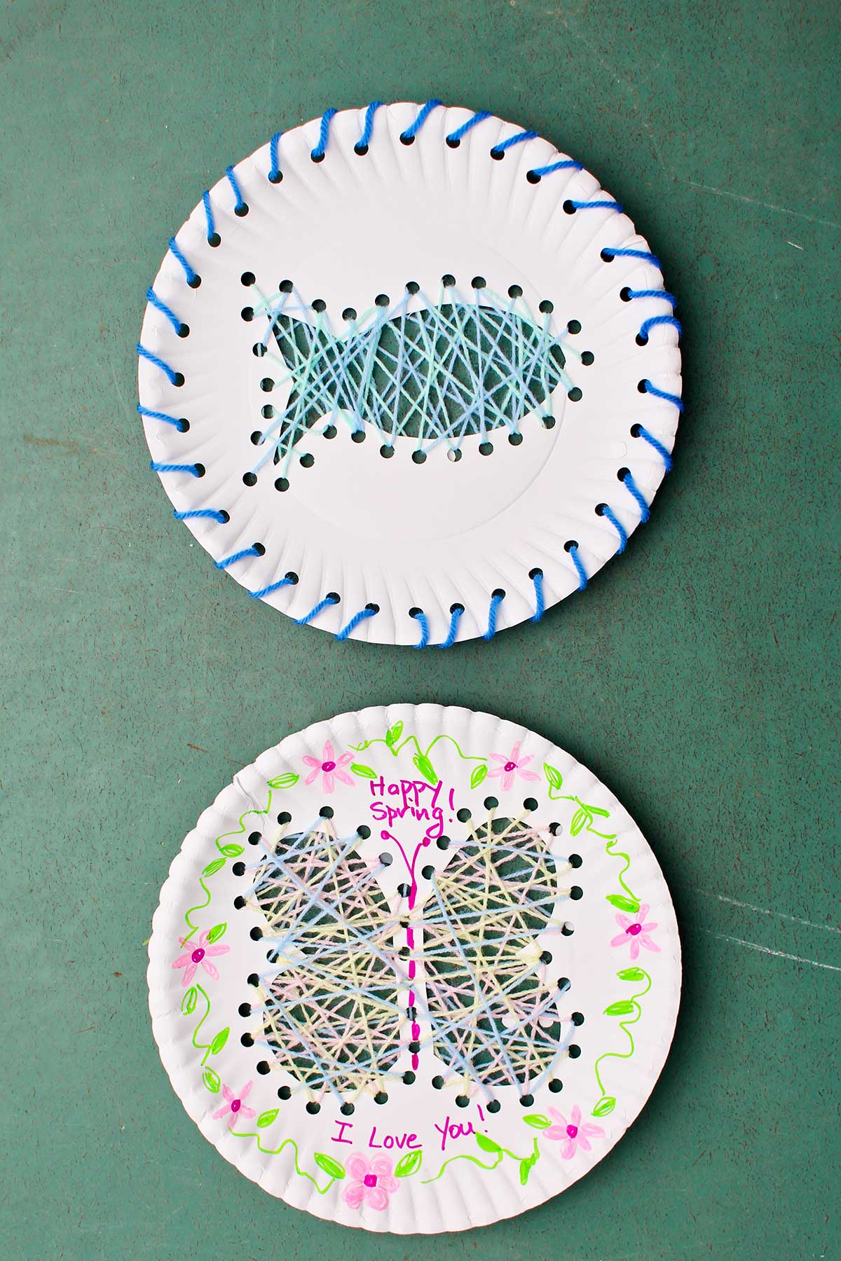 Two completed Paper Plate String Art projects. One of a fish with blue yarn and one of a butterfly with flower decorations and "Happy Spring" I Love You" written on the plate.