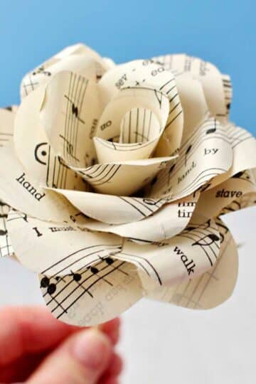 Hand holding completed Book Page Rose made from sheet music.