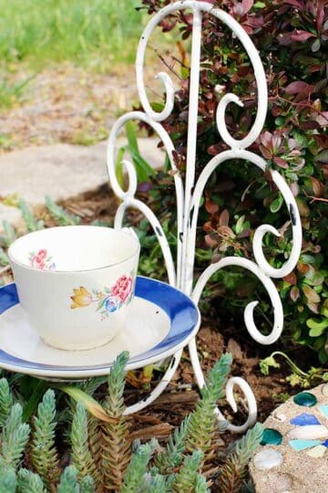 Teacup Bird Feeder resting in a garden.