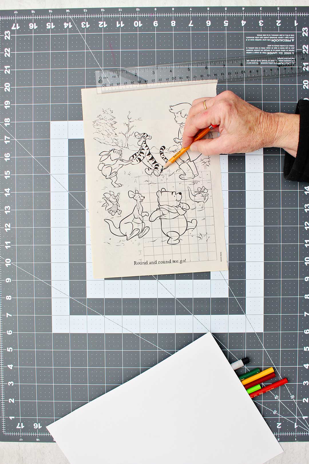 Hand sketching grid on original coloring page image of Winnie the Pooh.