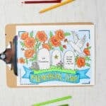 Completed Memorial Day Coloring Page on clip board. Coloring page has three headstones, flowers and bird and Memorial Day banner.