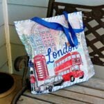 Cushion made from reusable shopping bag with scenes of London on it sitting on a bench.
