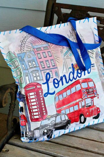 Cushion made from reusable shopping bag with scenes of London on it sitting on a bench.