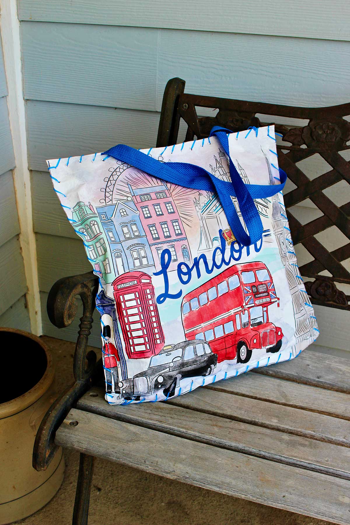 Reusable shopping bag sit upon cushion sitting on a bench.