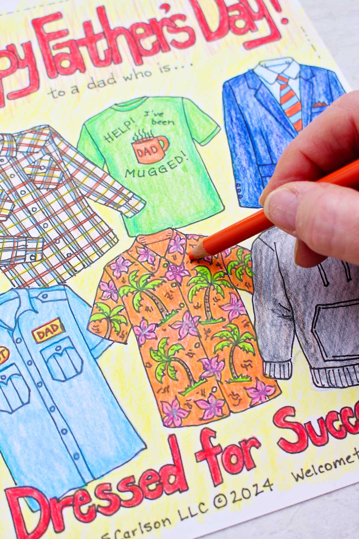 Close up view of a hand coloring a Hawaiian shirt orange on Father's Day Coloring Page.