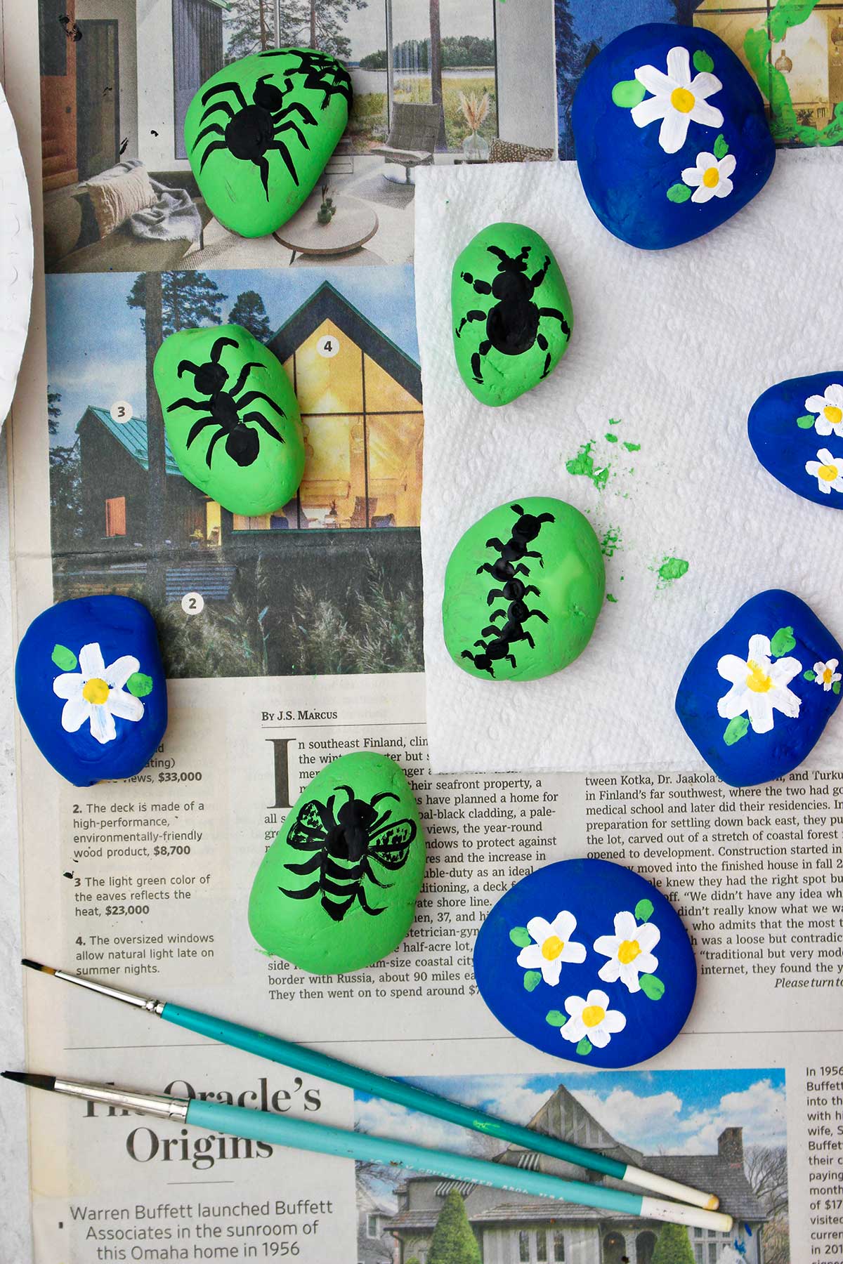 Completed painted rocks. Blue flower and green bugs.