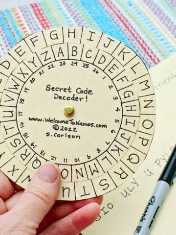 Person holding completed secret message decoder.