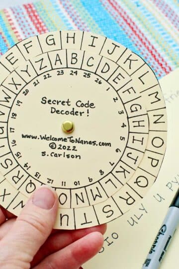 Person holding completed secret message decoder.