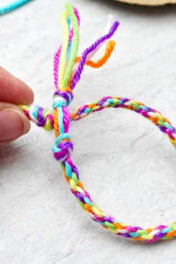 Person holding completed round friendship bracelet.