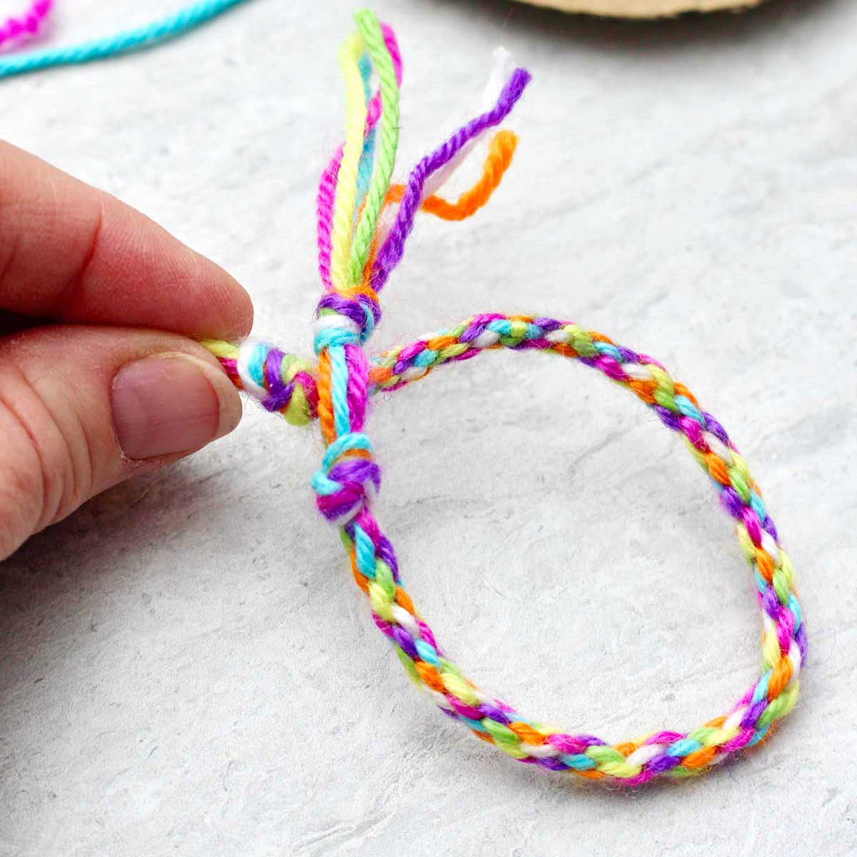 Person holding completed round friendship bracelet.