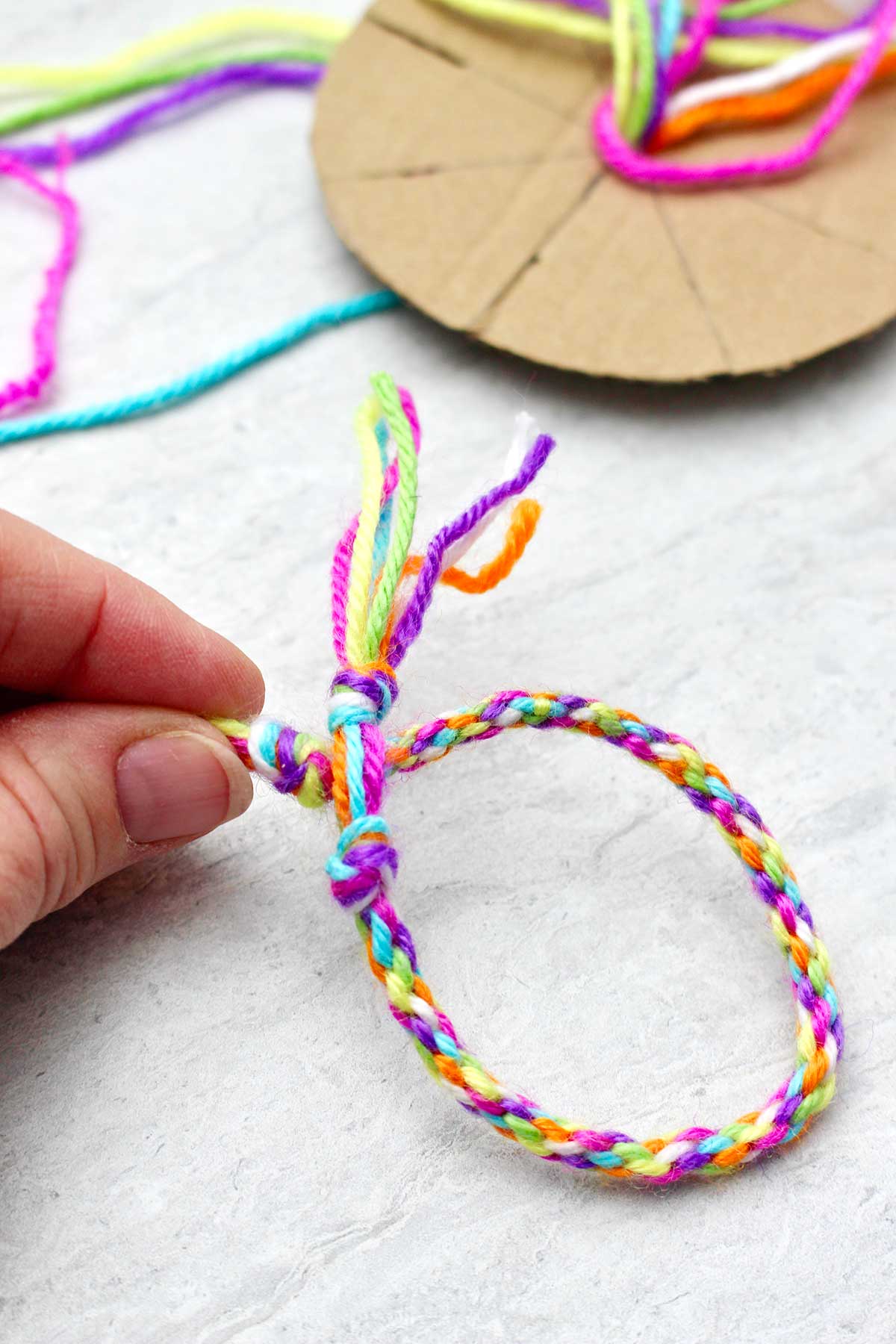 Person holding completed round friendship bracelet.