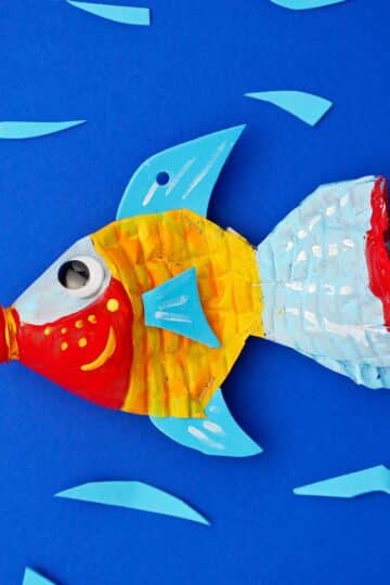 Plastic bottle fish painted red, yellow, blue and orange against a blue backdrop.