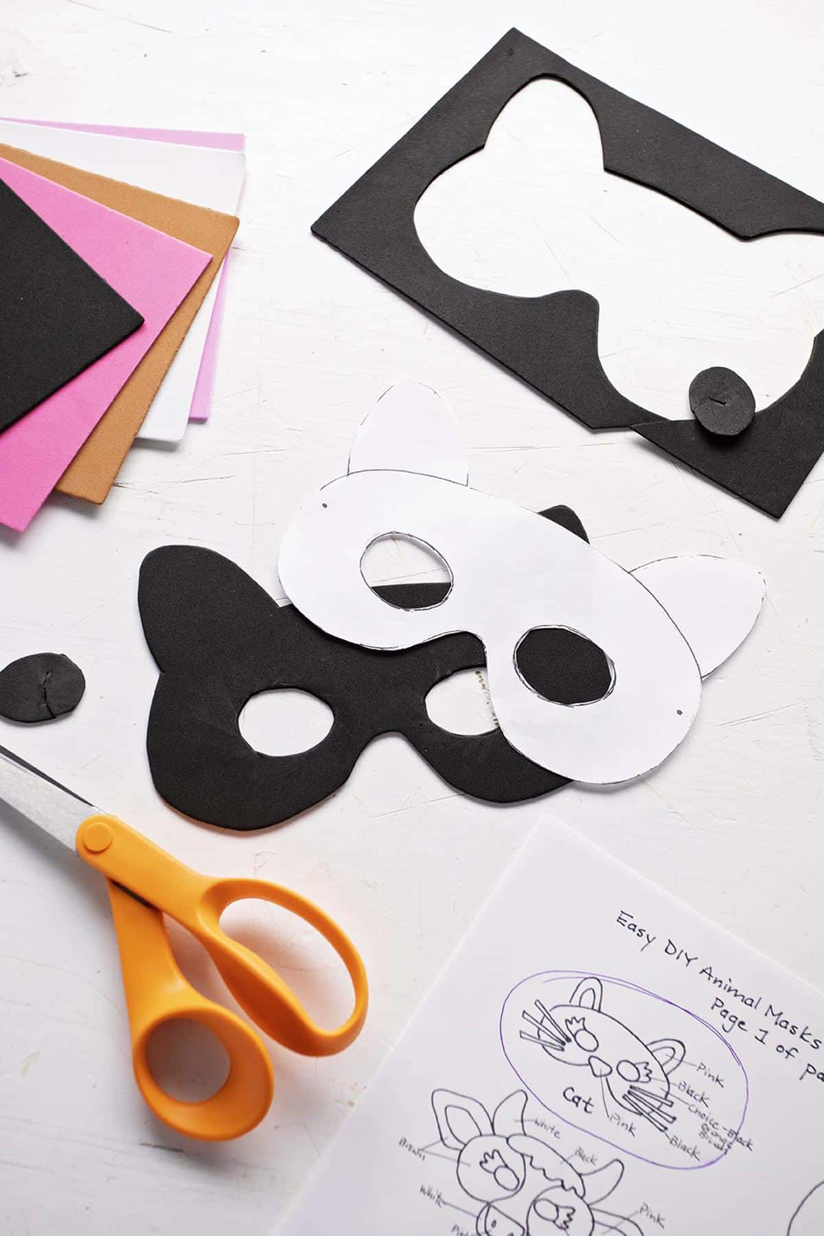 Craft foam, scissors, and a mask being cut from a template.