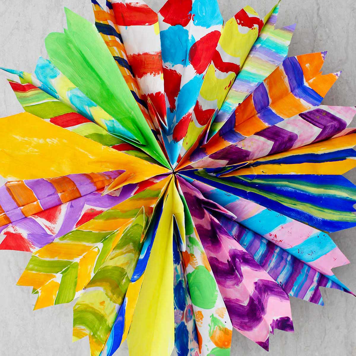 Completed colorful paper bag star made from multiple hand painted paper bags in different patterns.