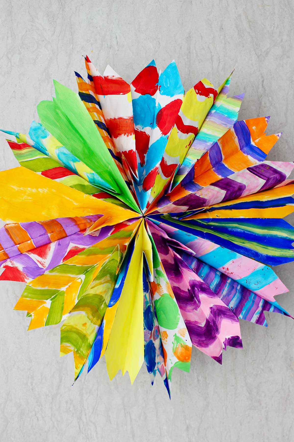 Completed colorful paper bag star made from multiple hand painted paper bags in different patterns.