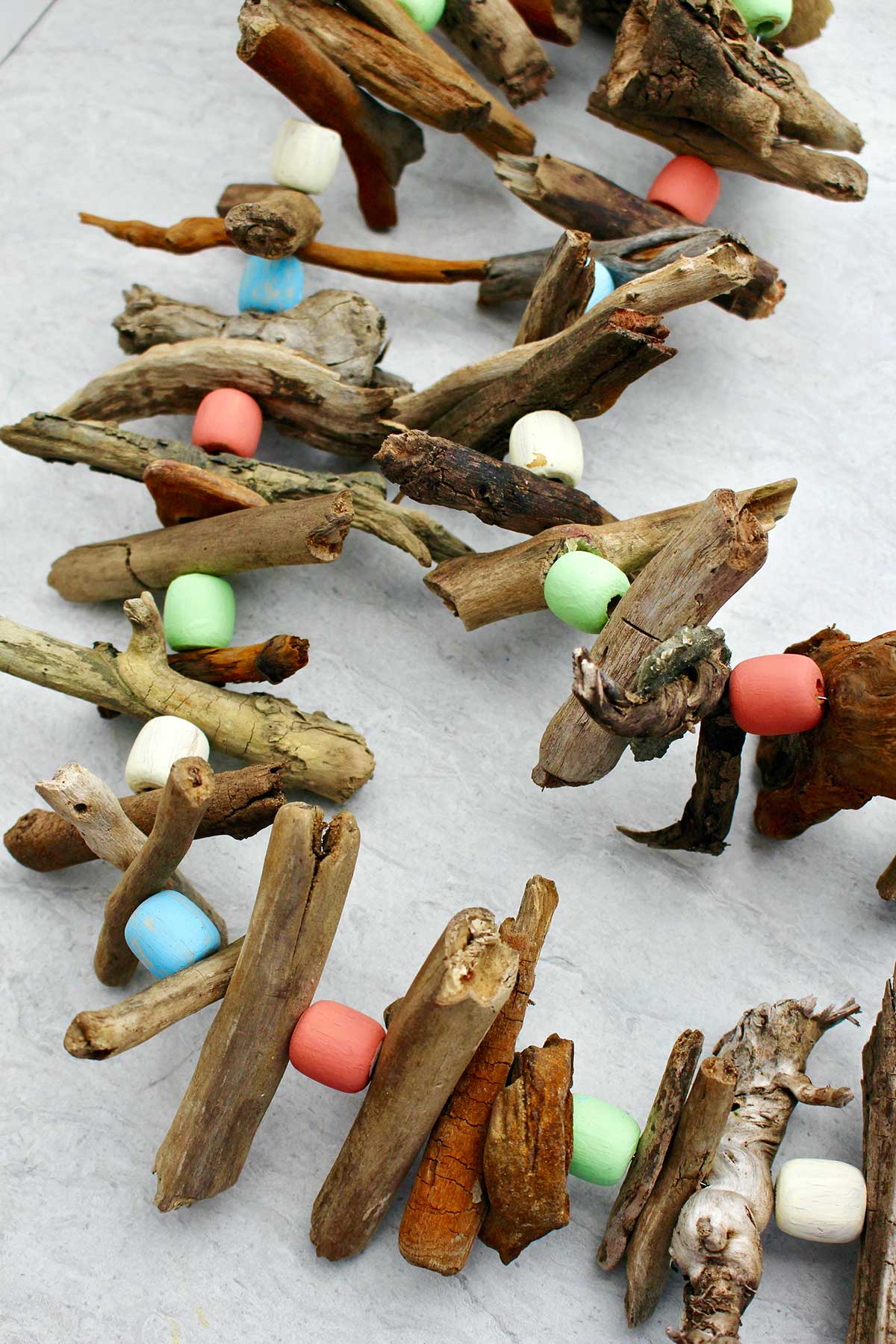 Close up of completed driftwood garland made with driftwood and painted wooden beads.