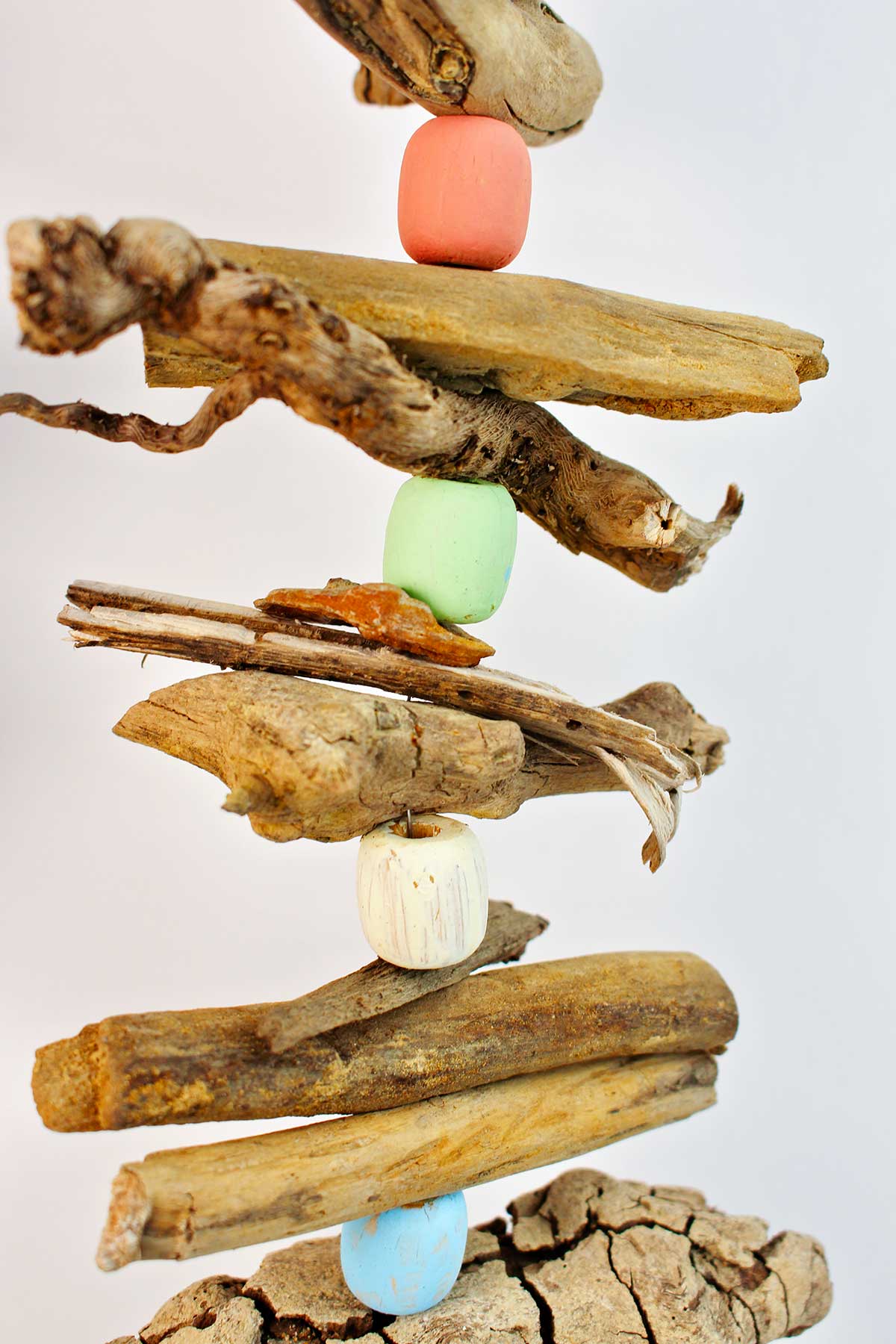 Close up of driftwood garland with driftwood and painted wooden beads.