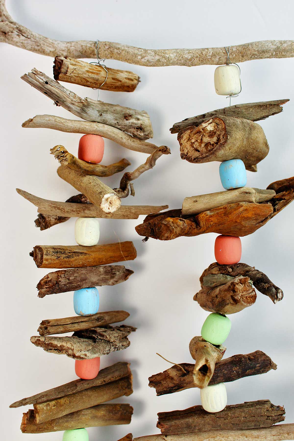 Driftwood garlands hanging from a wooden stick.