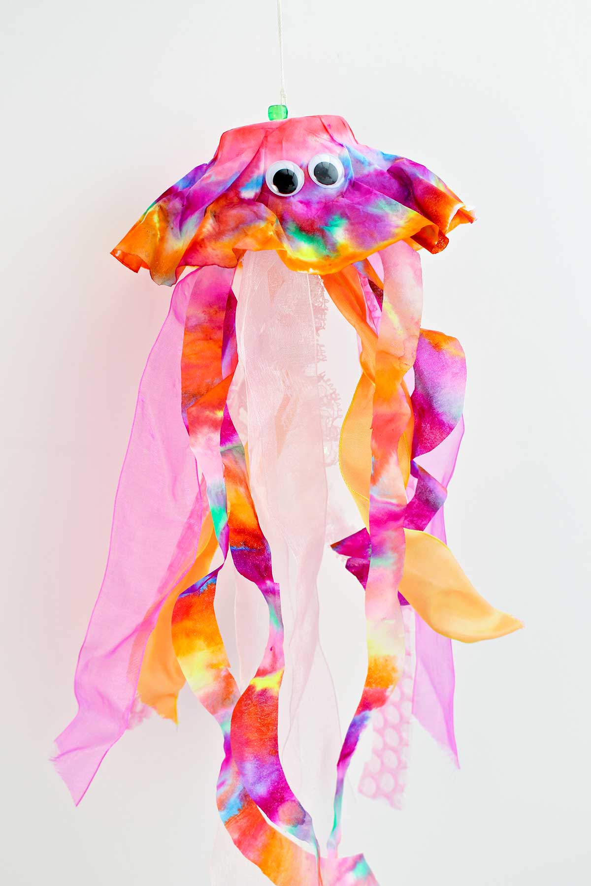 Pink, purple and orange coffee filter jellyfish with googly eyes.